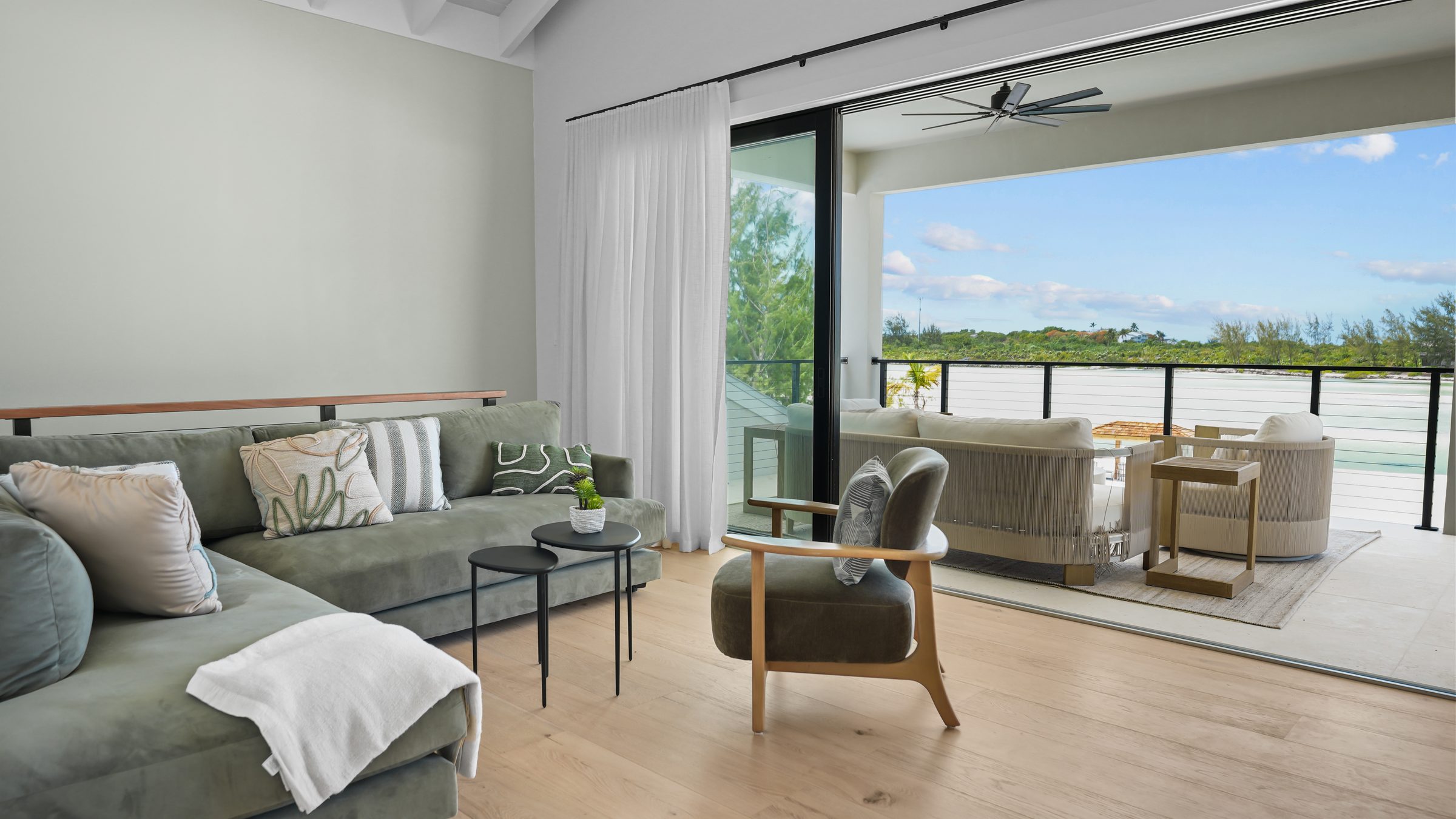 Great room opening to a terrace above a turquoise lagoon