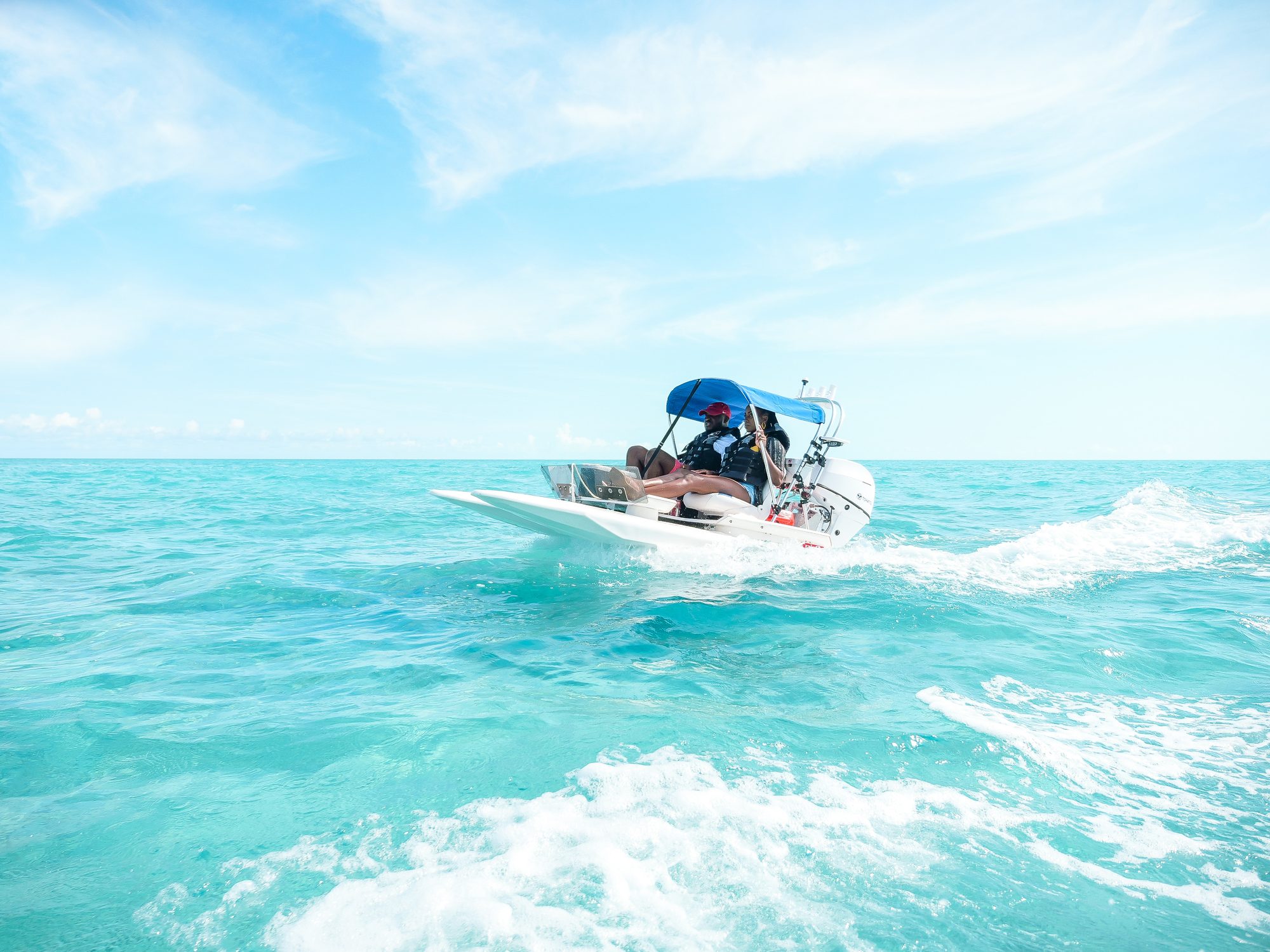 Small boat running across turquoise shallows